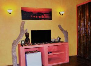 a living room with a red entertainment center with trees on the wall at Kwalucia Private Safari Retreat in St Lucia
