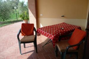 un patio con tavolo, 2 sedie, tavolo e sedie di Fattoria San Vincenzo a Marina di Grosseto