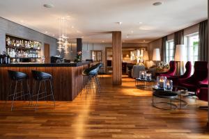 a bar at a hotel with chairs and tables at Hotel Patrizia in Tirolo