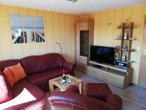 salon z kanapą i telewizorem w obiekcie Aquamarina w mieście Bansin