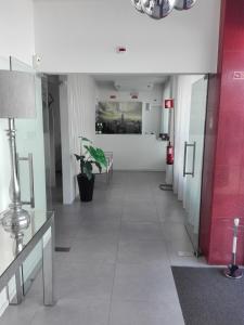um corredor de um edifício de escritórios com uma parede vermelha em Dom Joao Hotel em Entroncamento