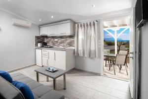 a kitchen and a living room with a couch and a table at De plata apartments in Sarti