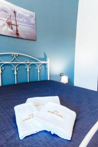 niebieska sypialnia z łóżkiem z 2 białymi poduszkami w obiekcie B&B Raggio di Sole Porto Empedocle w mieście Porto Empedocle