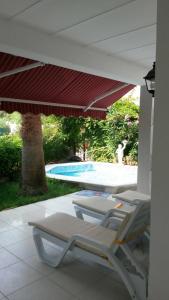 a pair of lounge chairs on a patio with a pool at Villa in Bodrum City