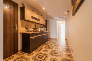 een keuken met een zwart aanrecht en een tegelvloer bij Willa Arkadia in Pobierowo