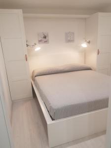 a white bedroom with a bed in a room at Camping Dal Pino in Marina di Massa
