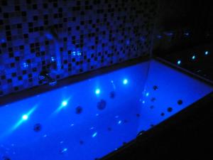 
a bathtub filled with lots of water next to a blue wall at Hostal Santo Domingo in Madrid
