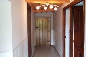 un corridoio vuoto con porta in legno in una stanza di A Minguxaina a Ribadeo