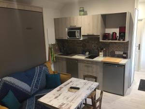 a kitchen with a table and a small kitchen with a couch at Gîtes Le Petit Nailly in Magny-les-Hameaux