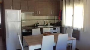 cocina con mesa y nevera blanca en Apartamento Las Eras, en Camarena de la Sierra