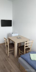 a dining room table with two chairs and a television at WHITE CORAL CLUB in Košice