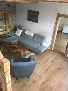 a living room with a blue couch and a table at Apartmán U Kapličky in Hluboká nad Vltavou