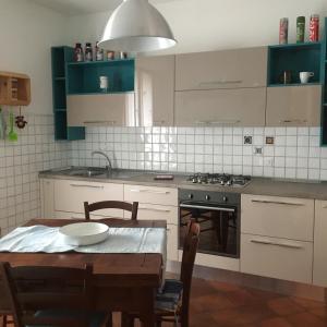 - une cuisine avec une table, une cuisinière et un évier dans l'établissement Appartamento Cristina, à Piombino