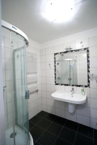 y baño con lavabo y ducha acristalada. en Bettina47 apartman, en Hajdúszoboszló