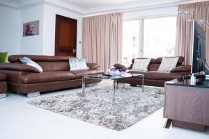 a living room with a leather couch and a coffee table at 90 Independence Avenue in Accra