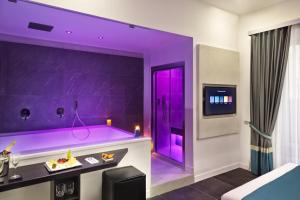 een paarse kamer met een bar en een tv bij Carten in Napels