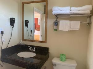 a bathroom with a sink and a mirror and towels at Wagon Wheel Motel in Salinas