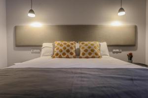 a bedroom with a large bed with two pillows at TRIA NOMINA Apartamentos Turísticos in Mérida