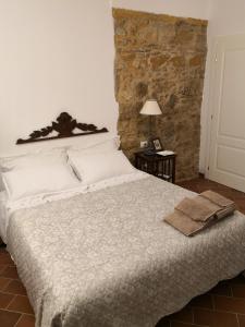 a bedroom with a large bed with a stone wall at Il Montedoro in Guardistallo