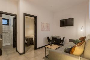 TRIA NOMINA Apartamentos Turísticos في ماردة: غرفة معيشة مع أريكة وطاولة