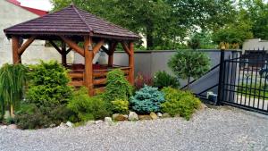 a wooden gazebo in a garden with plants at Noclegi AVATAR Radom in Radom