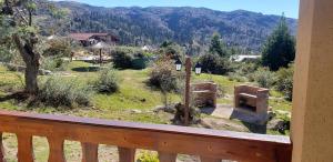 a balcony with a view of a field and mountains at Aires Serranos - Suites in La Cumbrecita