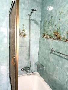 La salle de bains est pourvue d'une douche et d'une baignoire. dans l'établissement Apartamentos Garrett, à Horta