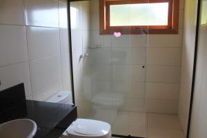 a bathroom with a shower with a toilet and a window at Casa da Montanha in Urubici