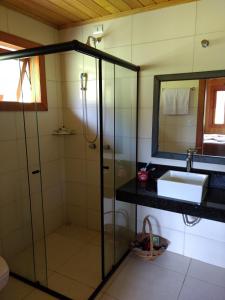 a bathroom with a shower and a sink and a mirror at Casa da Montanha in Urubici