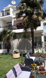 a house with a yard with a couch and palm trees at Villa Dolce Vita in Vodice