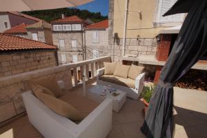 a balcony with a couch and a glass table at Apartments Galerija in Korčula