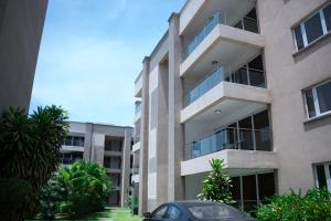 een appartementencomplex met een auto ervoor geparkeerd bij 90 Independence Avenue in Accra