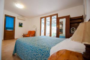 a bedroom with a large bed with a blue blanket at Albergo Macrì in Ischia