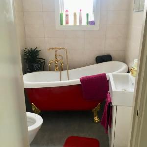 a bathroom with a red bath tub and a sink at Parkgatan villa in Krylbo +39 photos