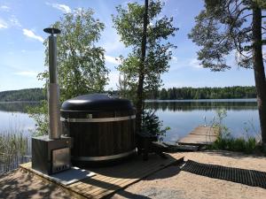 a large trash can sitting on a dock next to a lake at Antinkallio Lakeside Cape in Lahti