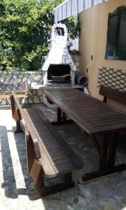 a wooden picnic table with a statue in the background at Villa Dolce Vita in Vodice