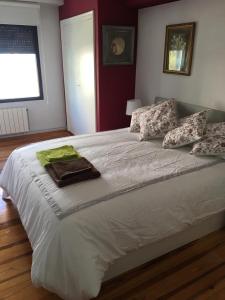 1 dormitorio con 1 cama blanca grande con almohadas en VISTAS AL MAR en Santander