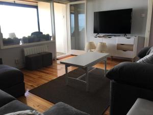 uma sala de estar com uma mesa e uma televisão de ecrã plano em VISTAS AL MAR em Santander