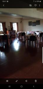 ein Wohnzimmer mit Tischen und Stühlen im Zimmer in der Unterkunft Hotel POSTA NORTE in Posadas