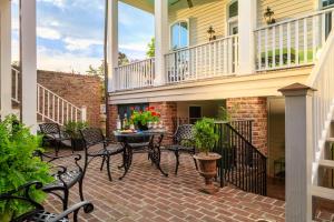 eine Terrasse mit Stühlen, einem Tisch und einem Balkon in der Unterkunft The Inn on West Liberty in Savannah