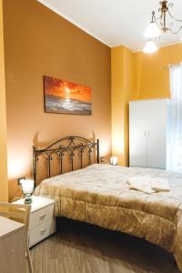 sypialnia z dużym łóżkiem z żółtymi ścianami w obiekcie B&B Raggio di Sole Porto Empedocle w mieście Porto Empedocle