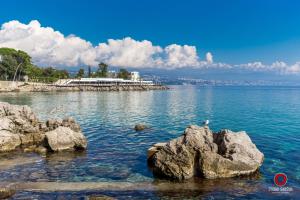 a large body of water with rocks in the water at Apartment Lucia in Rijeka