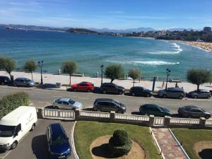 un aparcamiento con coches estacionados junto a la playa en VISTAS AL MAR en Santander