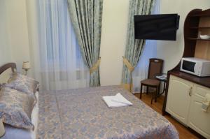 a bedroom with a bed with a microwave and a tv at Apartment nr. 8 in Odesa
