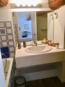 uma casa de banho com um lavatório e um espelho em Le Massilia de Steenia em Marselha