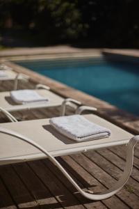 un sillón blanco junto a la piscina en Villa Juana Bungalows & Suites, en Punta del Diablo