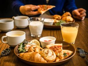 a table with a plate of food and a plate of pizza at Hotel Areaone Kitaibaraki in Kitaibaraki