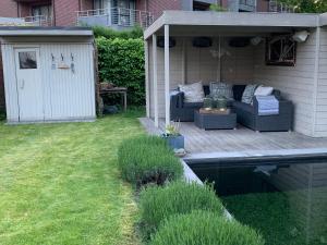a patio with a couch sitting on a deck next to a pool at Hasselt City Garden Duplex in Hasselt