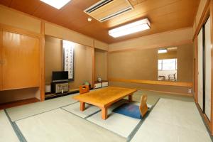 a dining room with a table and a television at Wakamatsu Honten in Narita