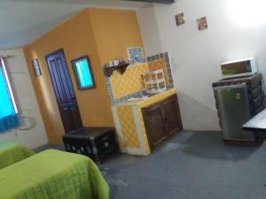 a room with two beds and a kitchen with a microwave at Loft Calicanto con Cochera in Guanajuato